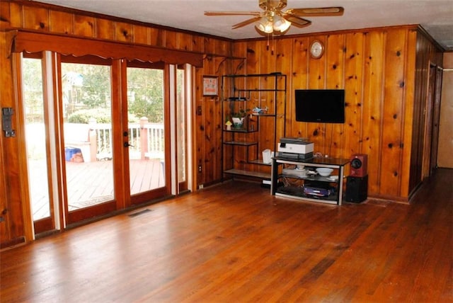 unfurnished living room with ceiling fan, plenty of natural light, ornamental molding, and hardwood / wood-style flooring