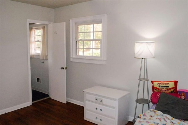 bedroom with dark wood-type flooring and multiple windows