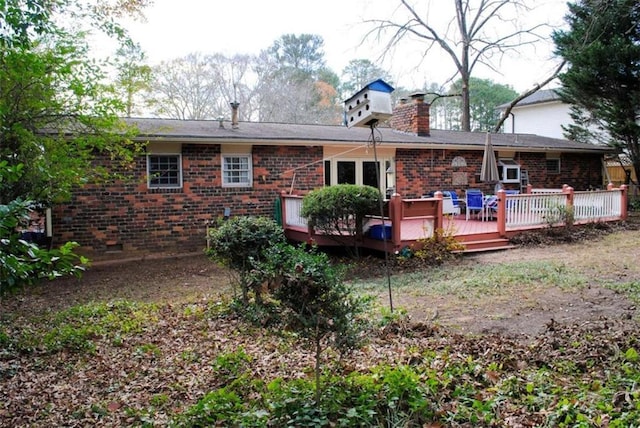 rear view of property featuring a wooden deck