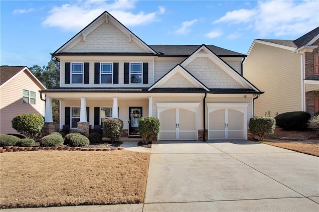 craftsman-style house with a garage, covered porch, and driveway