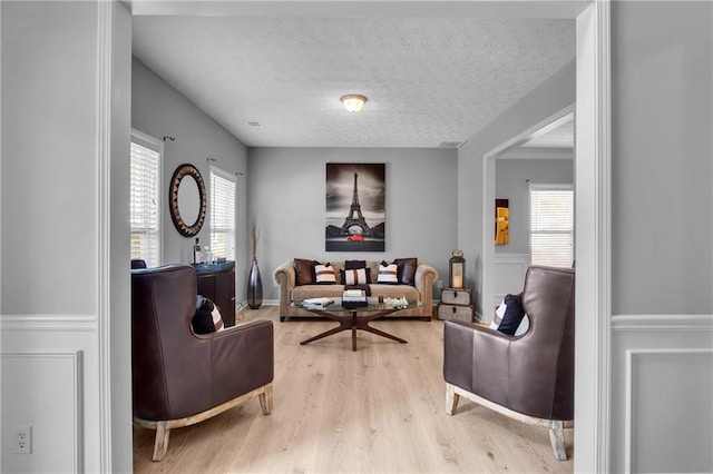 living area featuring a textured ceiling, plenty of natural light, and wood finished floors