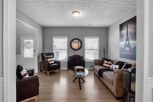 living room featuring light wood-style flooring and a textured ceiling