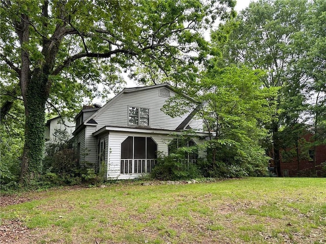 rear view of house with a yard and a sunroom