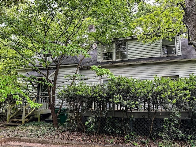 back of property featuring roof with shingles and a wooden deck