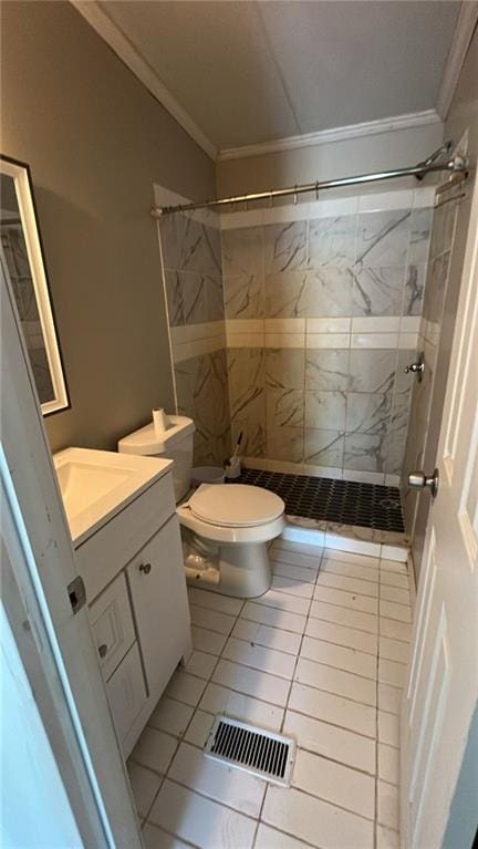 bathroom featuring vanity, toilet, tile patterned floors, and tiled shower