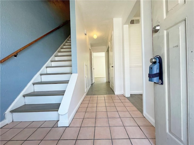 stairway with tile patterned floors