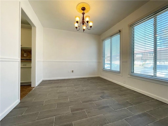 unfurnished room with a chandelier