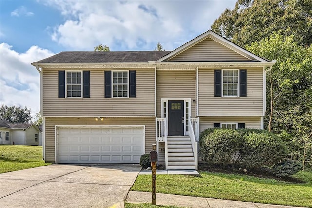 bi-level home featuring a garage and a front lawn