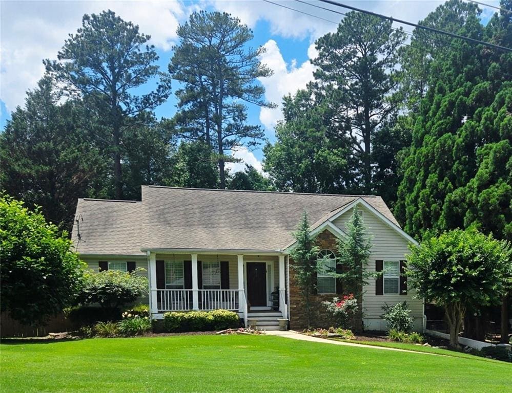 60 Stonehedge Dr, Buford, GA 30518 - view of front of house with a porch, a front lawn, and roof with shingles