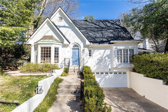 view of front of house featuring an attached garage, concrete driveway, and brick siding