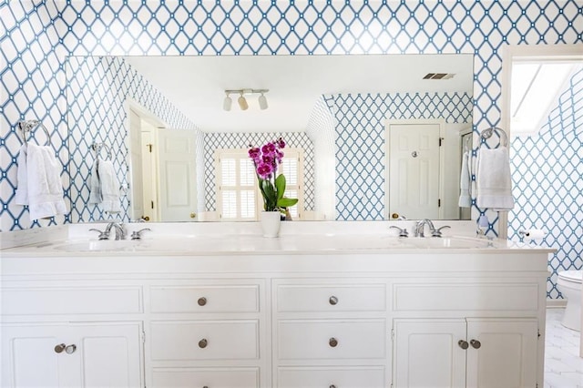 bathroom featuring visible vents, a sink, toilet, and wallpapered walls