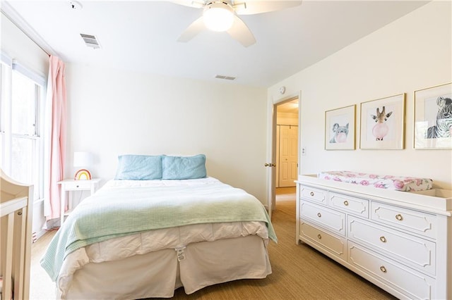 bedroom featuring light colored carpet, visible vents, and ceiling fan