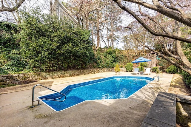 outdoor pool with a patio area and fence