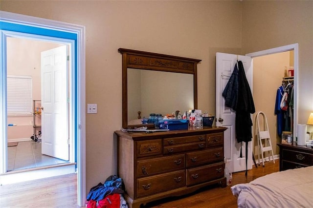 bedroom with hardwood / wood-style floors, a walk in closet, and a closet