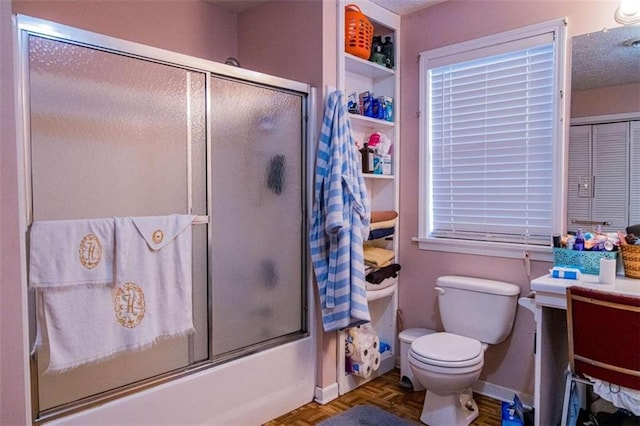 full bathroom with parquet flooring, vanity, toilet, and shower / bath combination with glass door