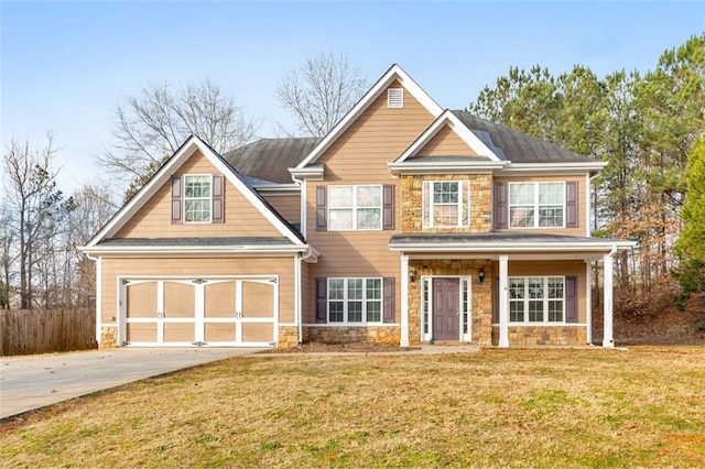 view of front facade featuring driveway, stone siding, fence, and a front lawn