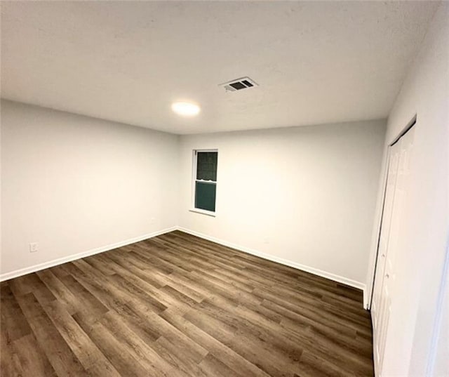 unfurnished room featuring dark wood-type flooring