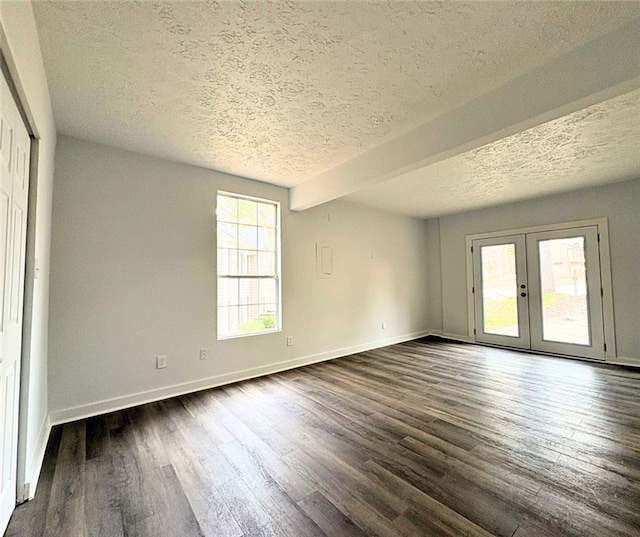 unfurnished room featuring dark wood-type flooring, french doors, and a textured ceiling