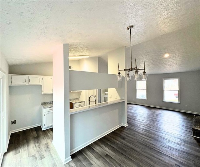 kitchen with sink, white cabinetry, decorative light fixtures, vaulted ceiling, and dark hardwood / wood-style floors