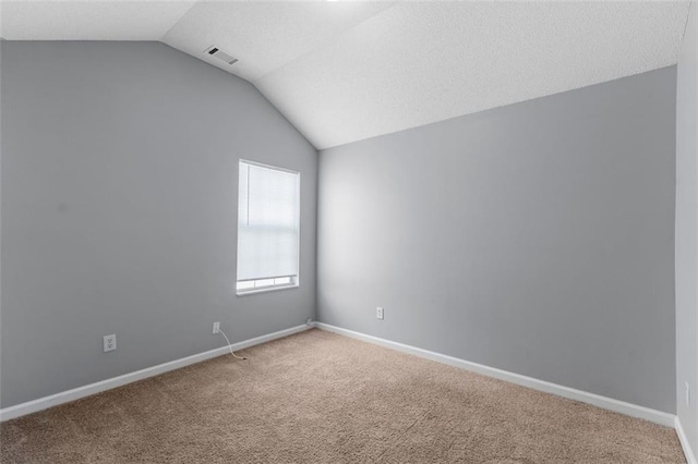 carpeted empty room featuring lofted ceiling