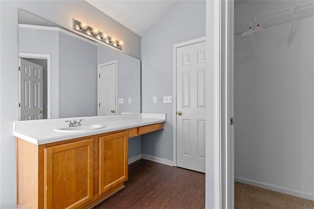 bathroom featuring hardwood / wood-style floors, vanity, and lofted ceiling