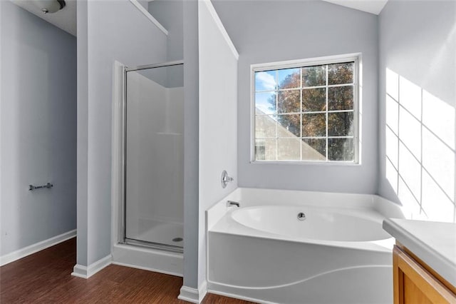 bathroom featuring independent shower and bath, vanity, and wood-type flooring