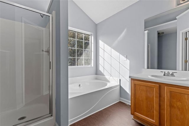 bathroom with vanity, hardwood / wood-style flooring, vaulted ceiling, and independent shower and bath