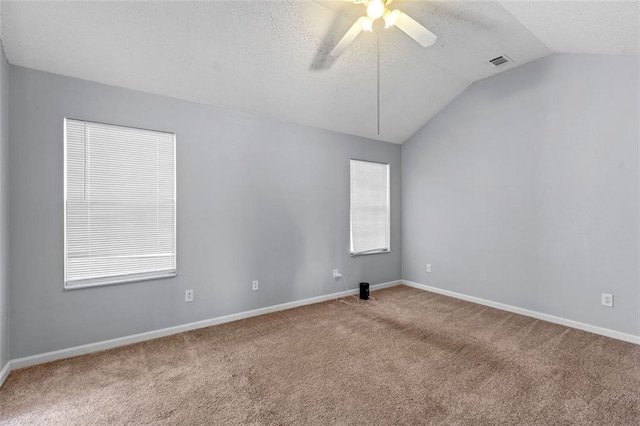 spare room featuring light carpet, a textured ceiling, ceiling fan, and lofted ceiling