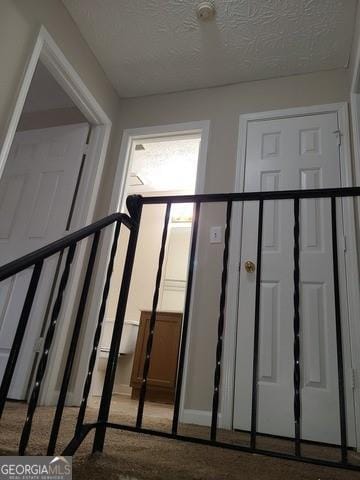 stairs featuring a textured ceiling