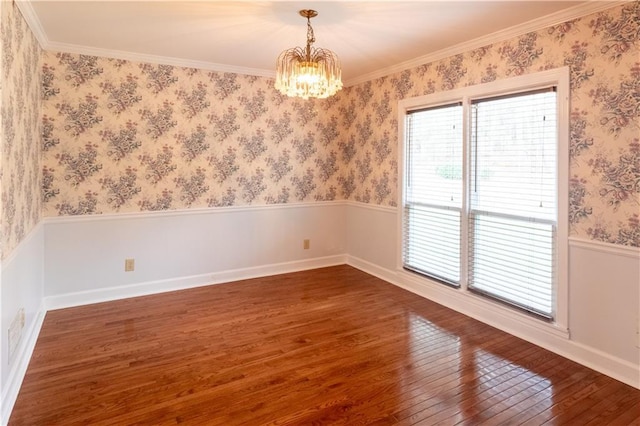 5150 Rockford Ln, Stockbridge, GA 30281 - spare room with an inviting chandelier, ornamental molding, a wainscoted wall, wallpapered walls, and wood-type flooring