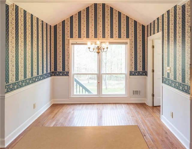 5150 Rockford Ln, Stockbridge, GA 30281 - empty room with plenty of natural light, wood-type flooring, and a notable chandelier