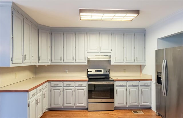 5150 Rockford Ln, Stockbridge, GA 30281 - kitchen featuring light wood-type flooring, under cabinet range hood, light countertops, and stainless steel appliances