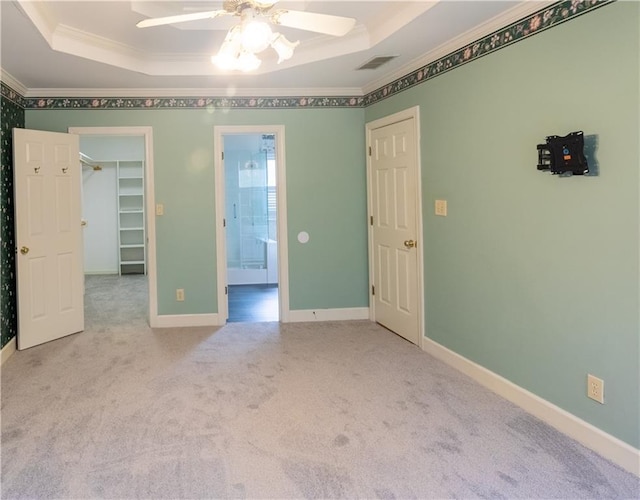 5150 Rockford Ln, Stockbridge, GA 30281 - carpeted spare room with visible vents, a tray ceiling, ornamental molding, and a ceiling fan