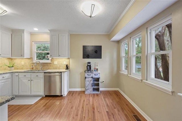3916 S Martin Way, Lithia Springs, GA 30122 - kitchen with decorative backsplash, stainless steel dishwasher, a sink, light wood-style floors, and white cabinetry