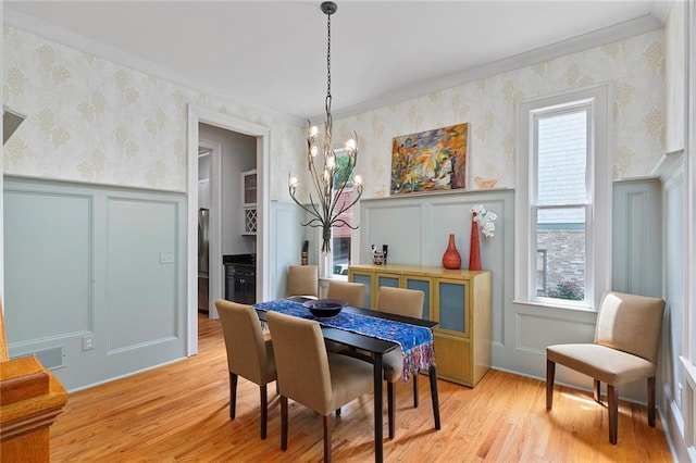 453 Carter Ave SE, Atlanta, GA 30317 - dining room with wallpapered walls, a decorative wall, plenty of natural light, a chandelier, and light wood-style floors
