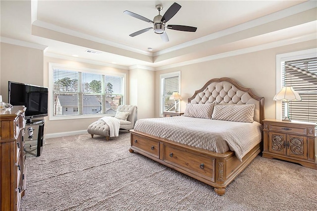 bedroom featuring visible vents, ornamental molding, a tray ceiling, and light colored carpet