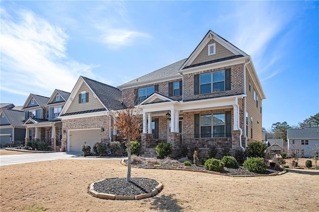 craftsman house with driveway, covered porch, an attached garage, and brick siding