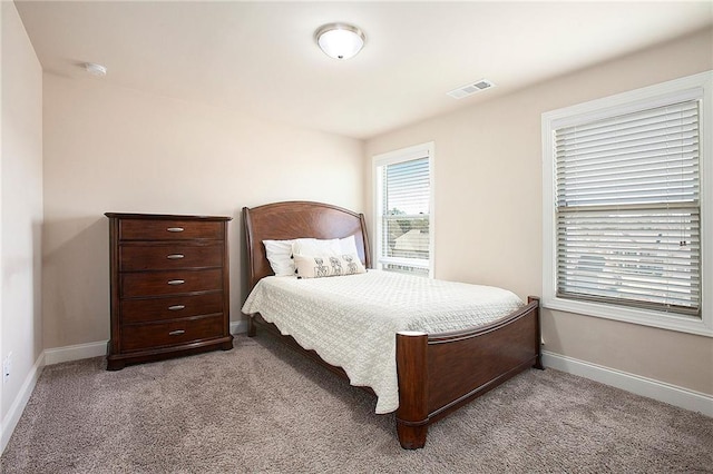 carpeted bedroom with visible vents and baseboards