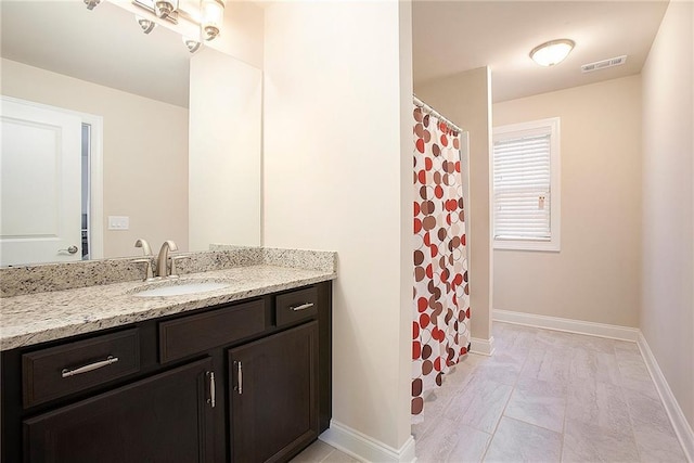 bathroom featuring baseboards, visible vents, and vanity