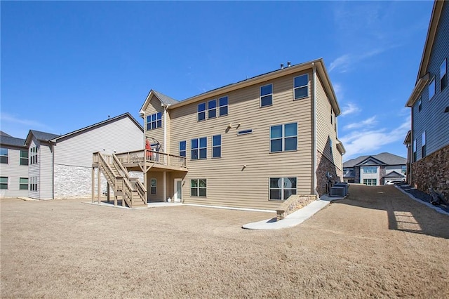 rear view of property with stairs, central AC, a deck, and a residential view