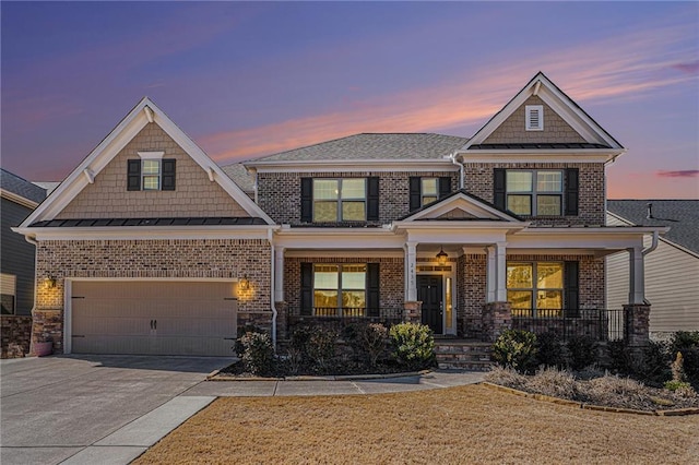 craftsman house with driveway, covered porch, a standing seam roof, and brick siding