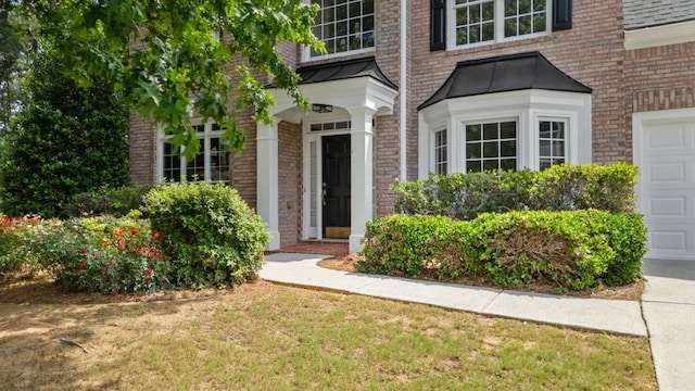 2934 Mill Grove Ter, Dacula, GA 30019 - view of exterior entry featuring brick siding, a garage, and a standing seam roof