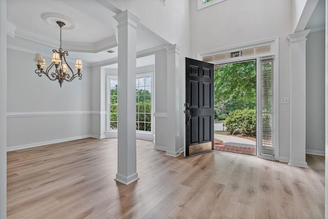 2934 Mill Grove Ter, Dacula, GA 30019 - foyer featuring a chandelier, wood finished floors, ornate columns, crown molding, and a raised ceiling