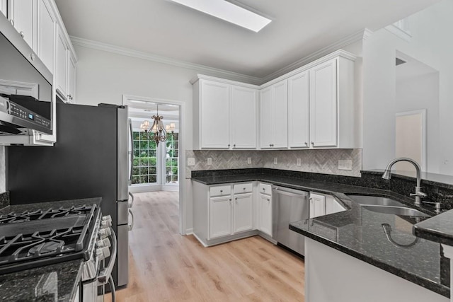 2934 Mill Grove Ter, Dacula, GA 30019 - kitchen with stainless steel appliances, dark stone counters, white cabinetry, and crown molding