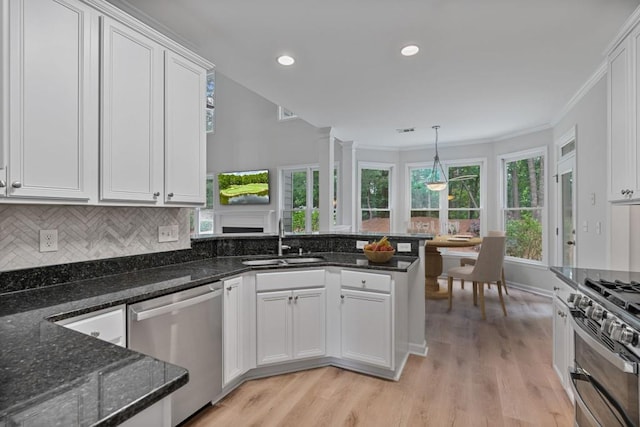 2934 Mill Grove Ter, Dacula, GA 30019 - kitchen with stainless steel appliances, a peninsula, white cabinets, light wood-style floors, and backsplash