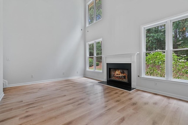 2934 Mill Grove Ter, Dacula, GA 30019 - unfurnished living room with a warm lit fireplace and wood finished floors