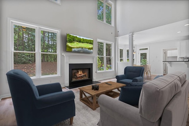 2934 Mill Grove Ter, Dacula, GA 30019 - living room with plenty of natural light, a fireplace with flush hearth, a towering ceiling, and light wood-style flooring