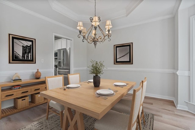 2934 Mill Grove Ter, Dacula, GA 30019 - dining space featuring a chandelier, light wood finished floors, a tray ceiling, and crown molding