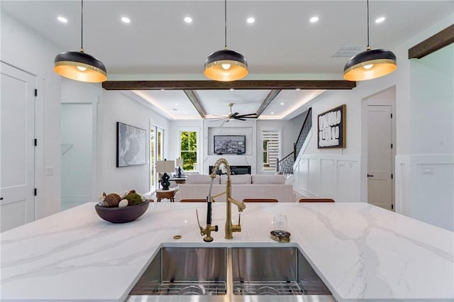 kitchen featuring recessed lighting, a sink, a large fireplace, open floor plan, and a center island with sink