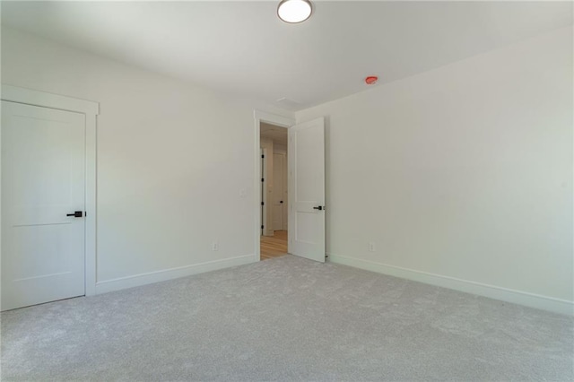 unfurnished room featuring carpet flooring and baseboards